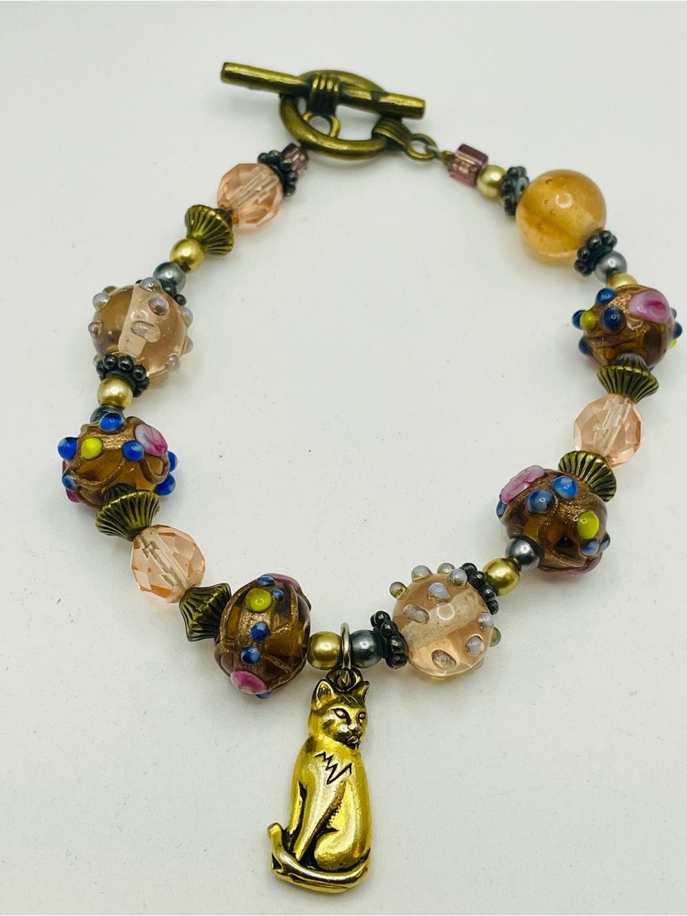 Gold Tone Cat Charm Glass Beaded Bracelet with Textured Floral and Swirl. 8 inch